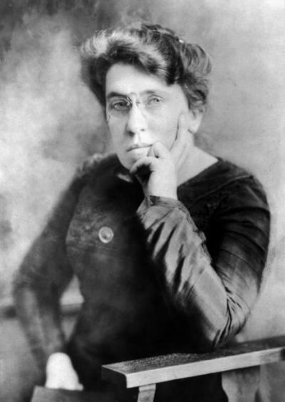 Portræt af en siddende Emma Goldmann med briller og sort kjole