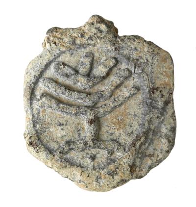En gammel mønt med en indgraveret menorah