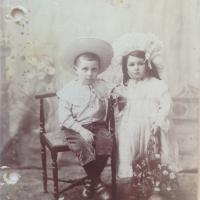 Gammelt billede af to børn, en dreng og en pige med hatte på